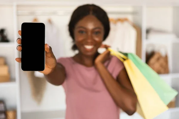 携帯電話の空画面広告アプリケーションを表示する黒の女性店で — ストック写真