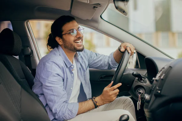 Gioioso ragazzo indiano che guida auto, guardando lo specchio retrovisore — Foto Stock