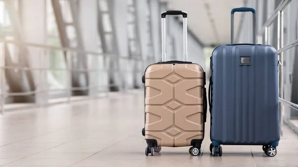 空の空港ホールに立つ2つのスタイリッシュなスーツケース、コピースペースのパノラマ — ストック写真