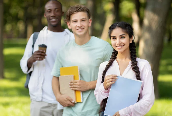 Amigos de la universidad. Retrato de adolescentes multiétnicos posando al aire libre con bloc de notas y libros, caminando en el campus universitario —  Fotos de Stock