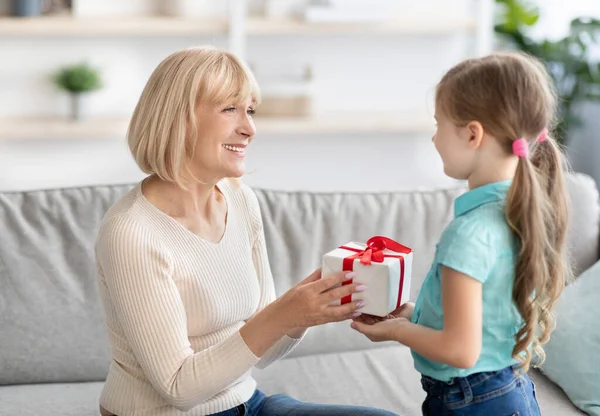 Little girl celebrating grannys day, greeting lady with box — Stock Photo, Image