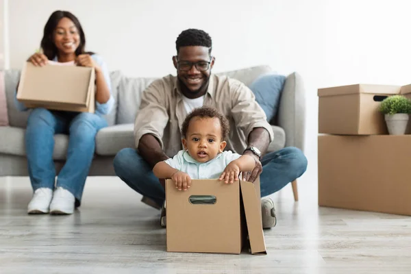 Захоплена чорна сім'я святкує день переїзду в новій квартирі — стокове фото