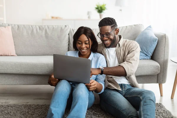 Porträt eines afroamerikanischen Paares mit Computer im Wohnzimmer — Stockfoto