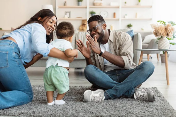 Schattige baby peuter wandelen in de woonkamer spelen met ouders — Stockfoto