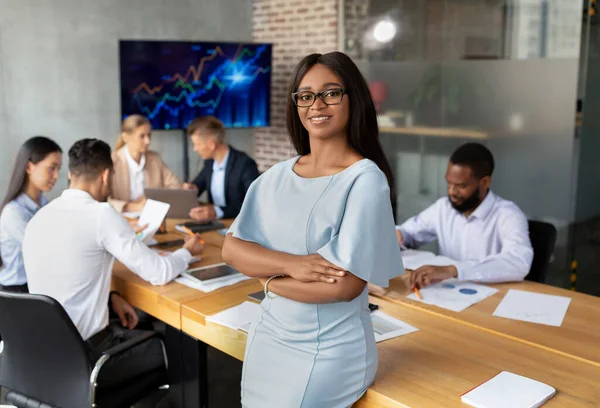 Liderança de negócios. Confiante Sorrindo Negra Empresária posando durante reunião de grupo no escritório — Fotografia de Stock