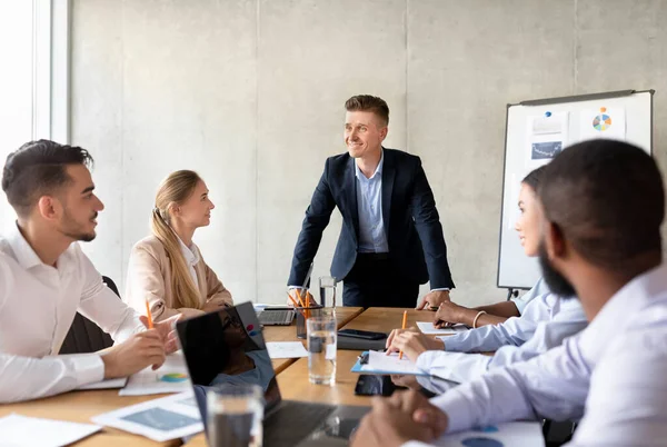 Corporate Meeting Concept. Confident Businessman Talking To Diverse Coworkers In Conference Room — Stock Photo, Image