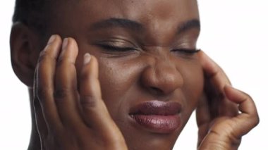 Baş ağrısı nöbeti. Mutlu olmayan, migrenden muzdarip, şakaklarına masaj yapan Afrikalı Amerikalı genç bir kadının portresi.