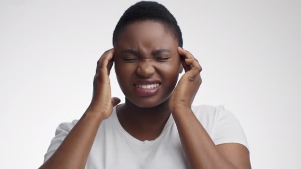 Migrénroham. Fiatal stresszes afro-amerikai nő szenved akut fejfájás, masszírozza a halántékát — Stock videók