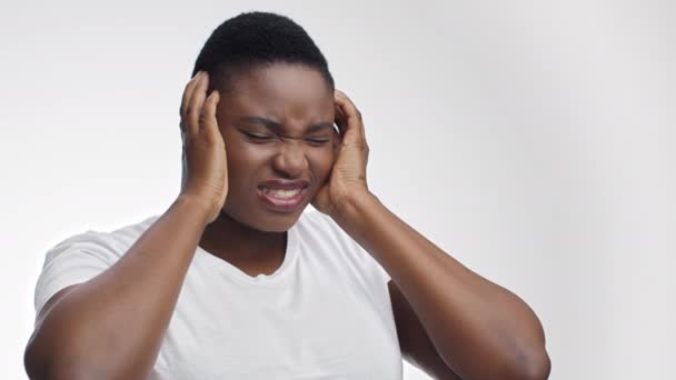 Giovane donna afroamericana sovrappeso che soffre di attacco di emicrania, toccando la sua testa dolorosa e smorzando — Video Stock