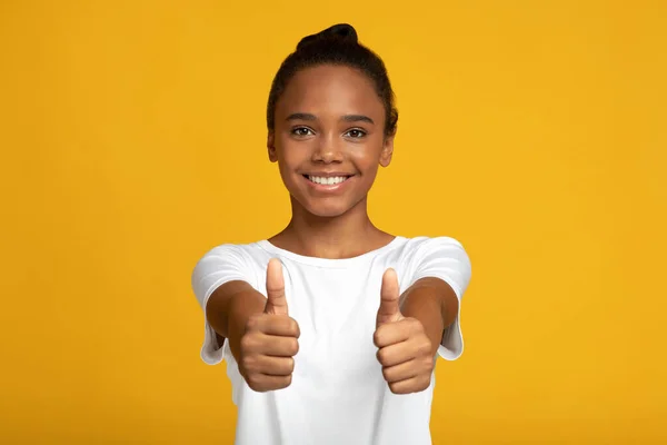 満足笑顔かなり十代のアフリカ系アメリカ人の女の子学生でホワイトtシャツショー親指アップジェスチャーとともに手 — ストック写真