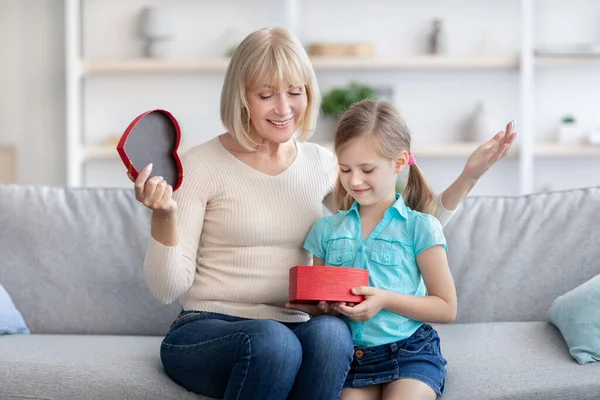 Little girl greeting mature lady giving box — Stock Photo, Image