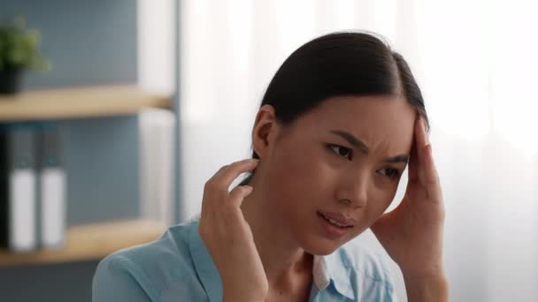 アジアのビジネスウーマンオフィスで頭痛の痛みに苦しむ寺院をマッサージ — ストック動画