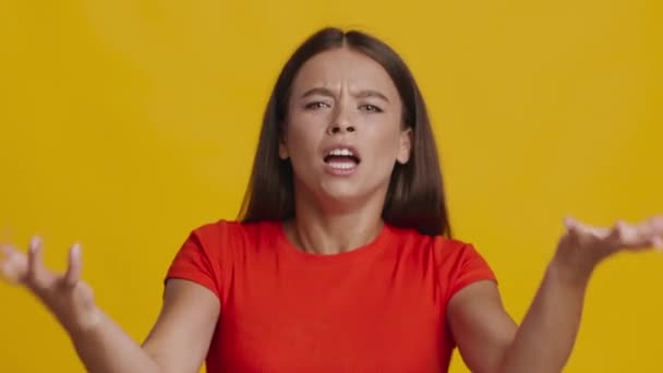 Hullu nainen huutaa vapina kädet ilmaista aggressiota yli keltainen tausta — kuvapankkivideo