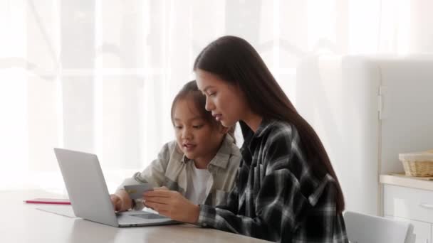 Japońska matka i córka przy użyciu laptopa i karty kredytowej w pomieszczeniach — Wideo stockowe