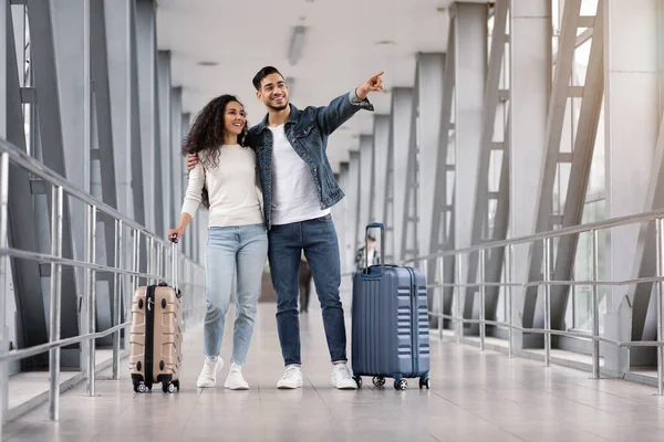 Viajando juntos. Joven pareja árabe feliz de pie con maletas en la terminal del aeropuerto — Foto de Stock