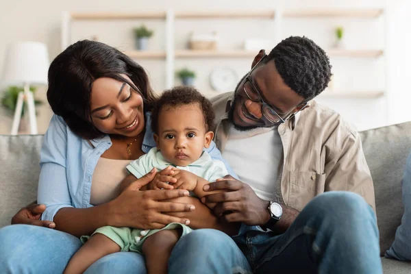 Портрет счастливой чёрной семьи, улыбающейся, глядя на ребёнка — стоковое фото