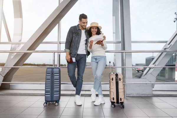 Esperando por el vuelo. Pareja árabe feliz de pie en la terminal del aeropuerto con maletas — Foto de Stock