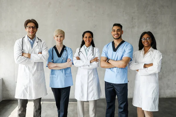 Equipe médica multirracial posando na clínica enquanto tem formação de equipe — Fotografia de Stock