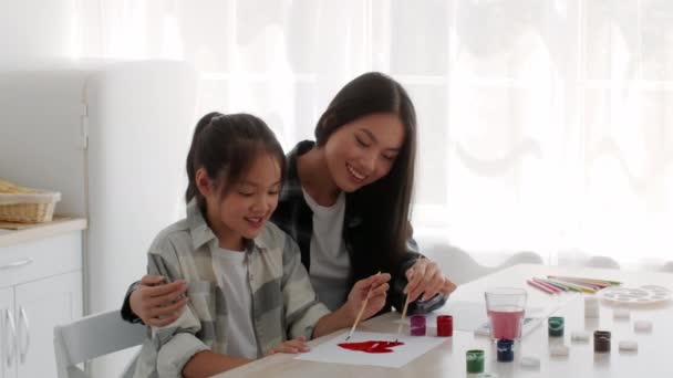 幸せなアジアのお母さんと小さな娘が家で一緒に絵を描く — ストック動画