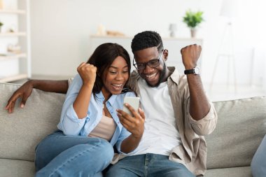 Afrikalı Amerikalı çift cep telefonuyla zaferi kutluyor.