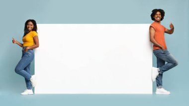 Kaygısız afro-amerikan aşıklar boş bir pankartın yanında duruyorlar.