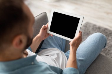 Ev ofisinde boş ekranı olan tablet bilgisayarda çalışan tanınmayan genç adam, web sitesi veya uygulama için model