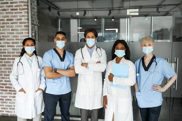 Międzynarodowy zespół medyczny w maskach twarzy mający budowanie zespołu — Zdjęcie stockowe