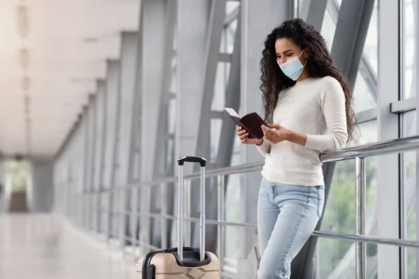 Mujer joven con máscara médica esperando el vuelo en la terminal del aeropuerto —  Fotos de Stock
