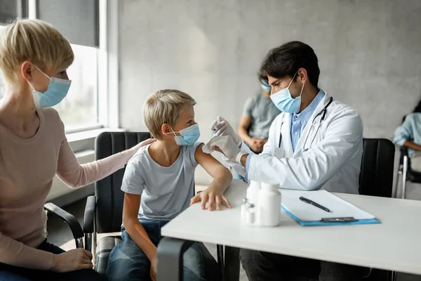 Adolescente chico siendo vacunado contra coronavirus en clínica —  Fotos de Stock