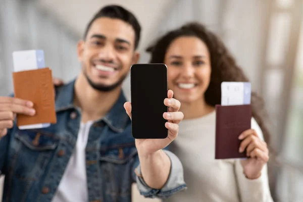 Pasaportlu ve Biletli Mutlu Arap Çift Boş Ekranlı Akıllı Telefon Gösteriyor — Stok fotoğraf