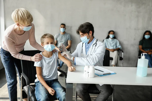 Adolescente chico recibiendo inyección intramuscular contra coronavirus — Foto de Stock