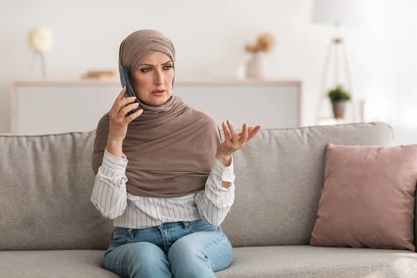 Soddisfatto anziano musulmano femminile parlare al telefono seduto a casa — Foto Stock