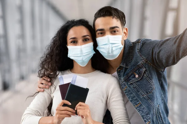 Viaje Selfie. Joven pareja árabe con máscaras médicas tomando fotos en el aeropuerto —  Fotos de Stock