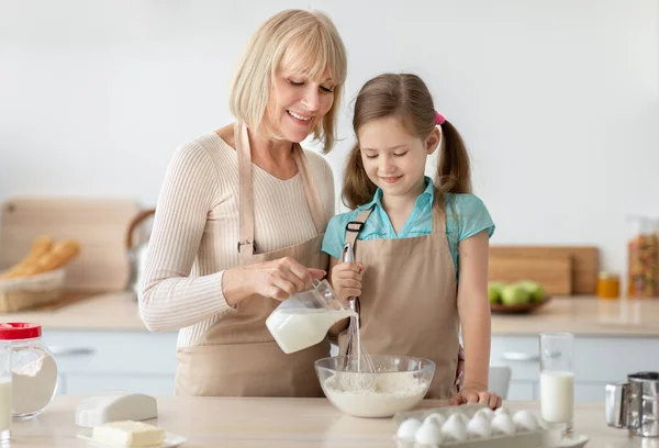 Glückliche Seniorin und ihre Enkelin beim Teigkneten — Stockfoto