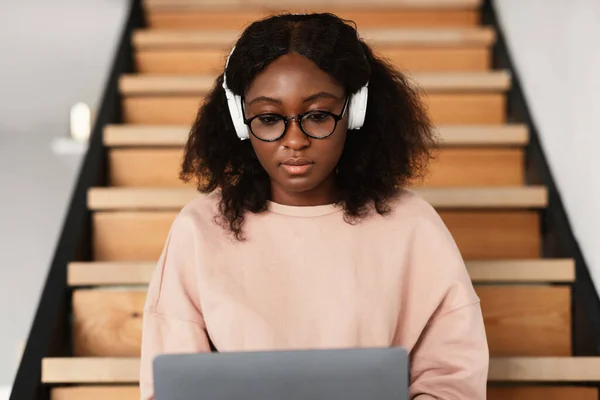 Evde kulaklık takan, dizüstü bilgisayar kullanan Afrikalı Amerikalı Serbest Çalışan Kadın. — Stok fotoğraf