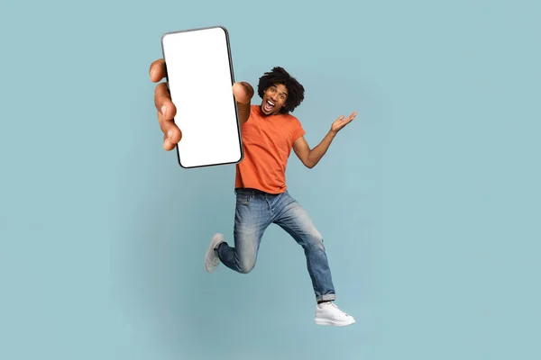 Pozytywny afro-amerykański facet pokazuje duży smartfon z pustym ekranem — Zdjęcie stockowe