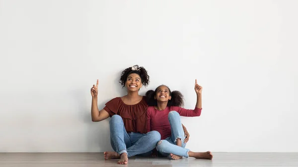 Linda mãe e filha afro-americana apontando para cima, espaço de cópia — Fotografia de Stock