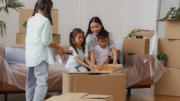 Família coreana comendo pizza comemorando a mudança para a nova casa — Vídeo de Stock