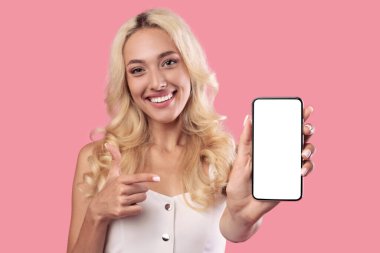 Beyaz, boş akıllı telefon ekranını tutan ve işaret eden kadın