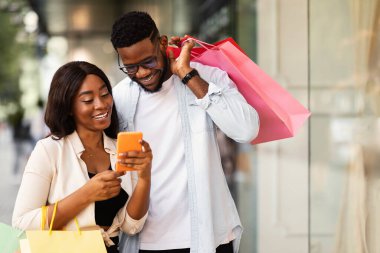 Alışveriş çantalı mutlu siyah çift.