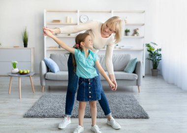 Küçük kızla dans eden pozitif büyükanne.