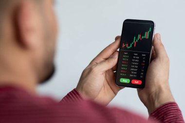 Ortadoğulu işadamı akıllı telefon ve kolajda ticaret uygulaması kullanıyor
