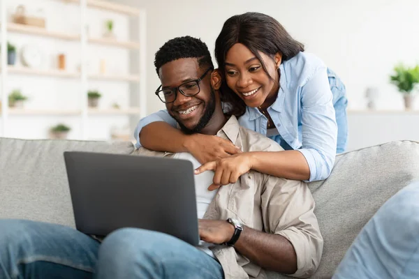 Retrato de pareja afroamericana usando computadora apuntando a la pantalla —  Fotos de Stock