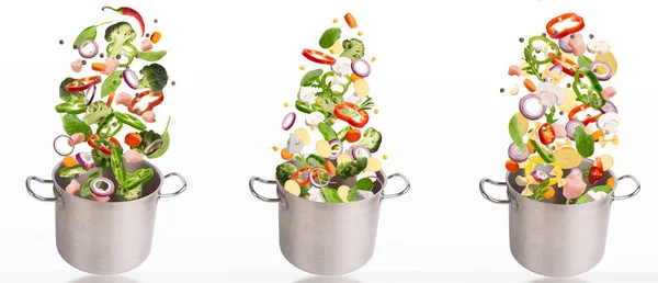 Fresh vegetables and raw meat flying into steel stewpot — Stock Photo, Image