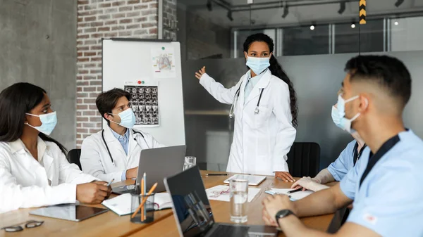 Grupo multirracial de médicos con máscaras faciales que tienen una conferencia médica —  Fotos de Stock