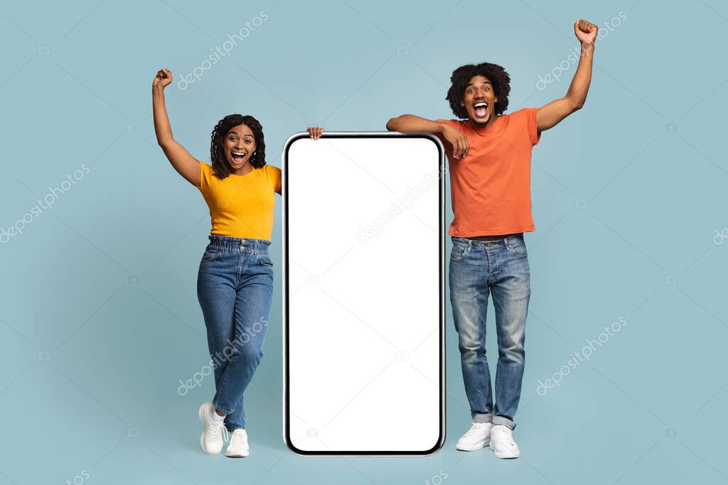 Excited african american man and woman with big mobile phone