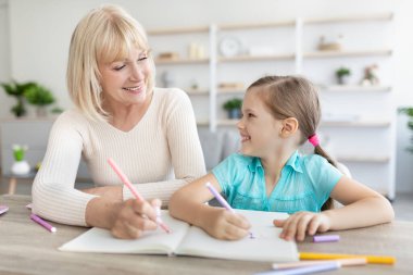 Büyük anne ve torununun portresi. Evde vakit geçiriyorlar, resim çiziyorlar.