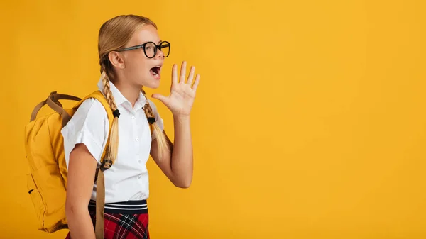 Vtipné dospívající blondýnka dívka žák s copánky, batoh v brýlích křičí na volné místo — Stock fotografie