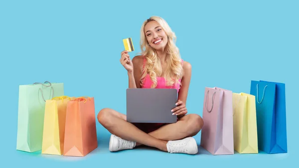 Mulher feliz com sacos de compras, laptop e cartão de plástico — Fotografia de Stock