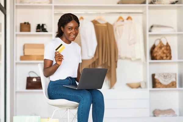 黑色女性在衣橱里使用笔记本电脑和信用卡购物 — 图库照片